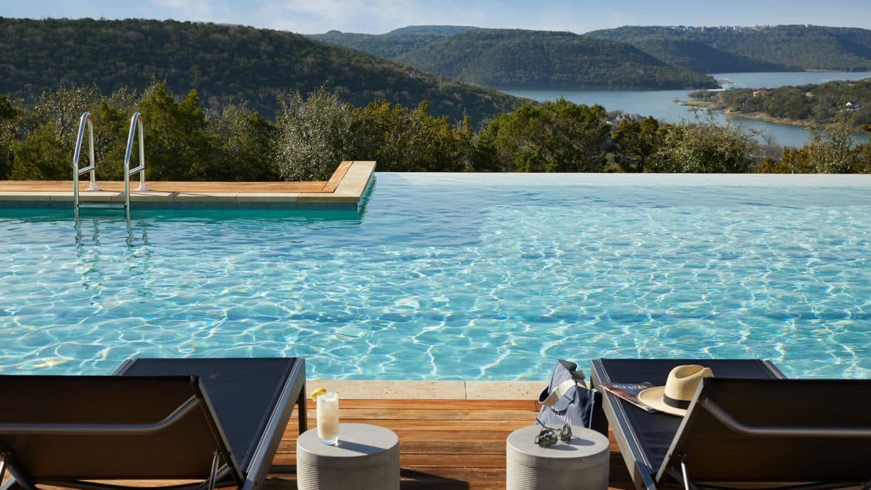 two lounge chairs beside a pool